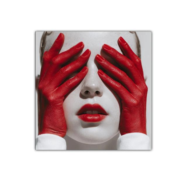 Impactante expresión con manos rojas sobre rostro pálido