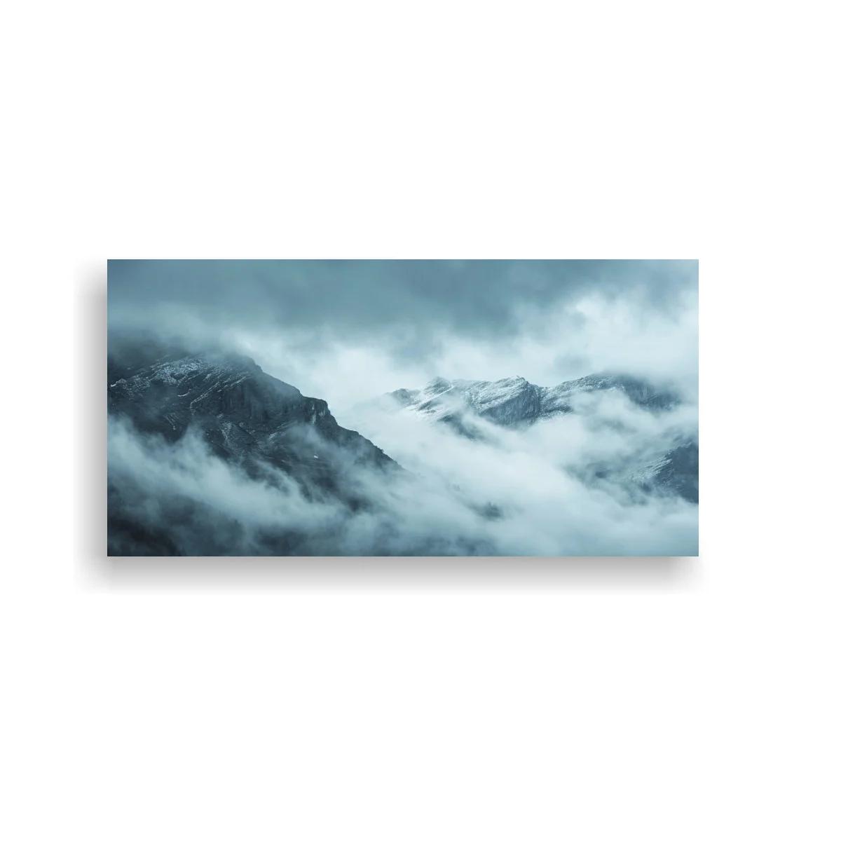 Cuadro montañas nevadas entre niebla con nubes bajas
